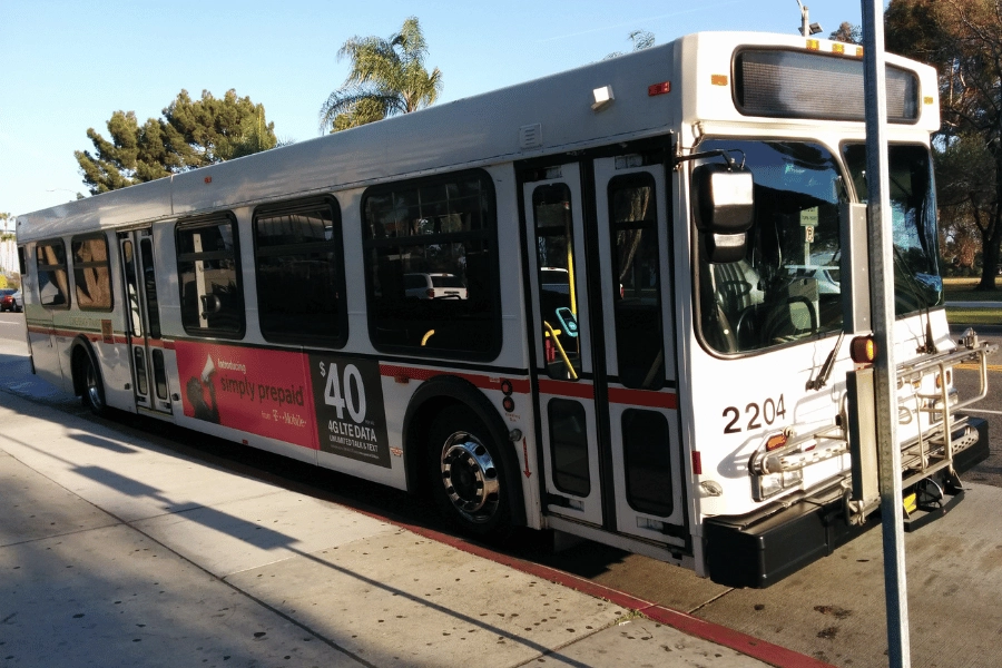 white city bus parked on the side of the street